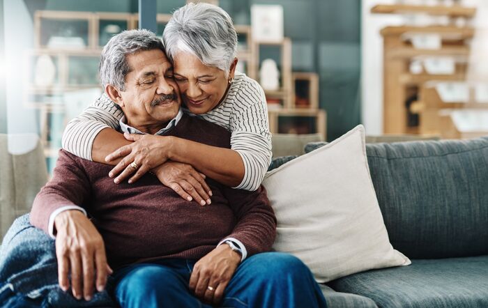 woman with arms around man in living room setting